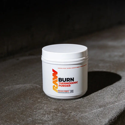 Raw Nutrition Burn Thermogenic Powder 516g jar on concrete surface, designed for energy and improved focus.