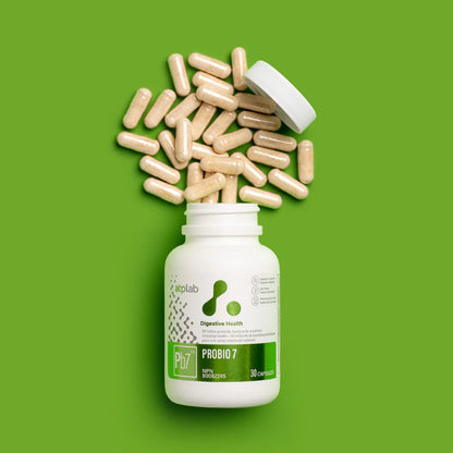 ATP Lab ProBio7 probiotic supplement bottle with capsules spilling out on a green background