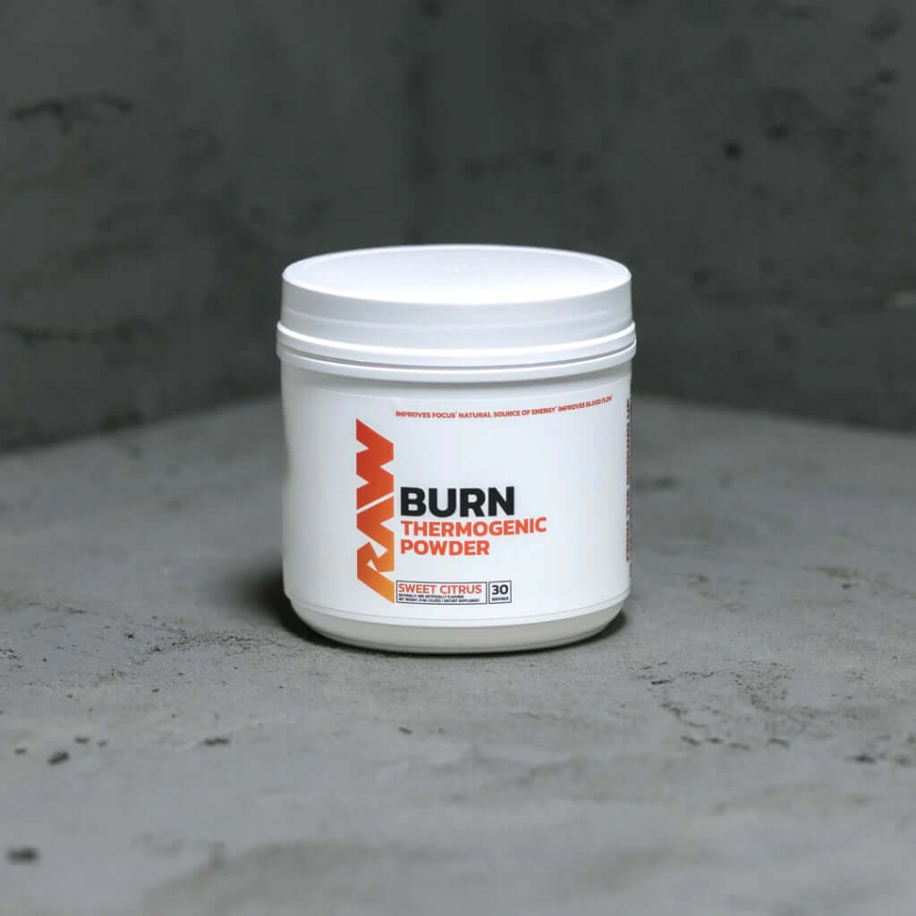 Raw Nutrition Burn thermogenic powder container on a textured surface, designed to boost metabolism and energy.